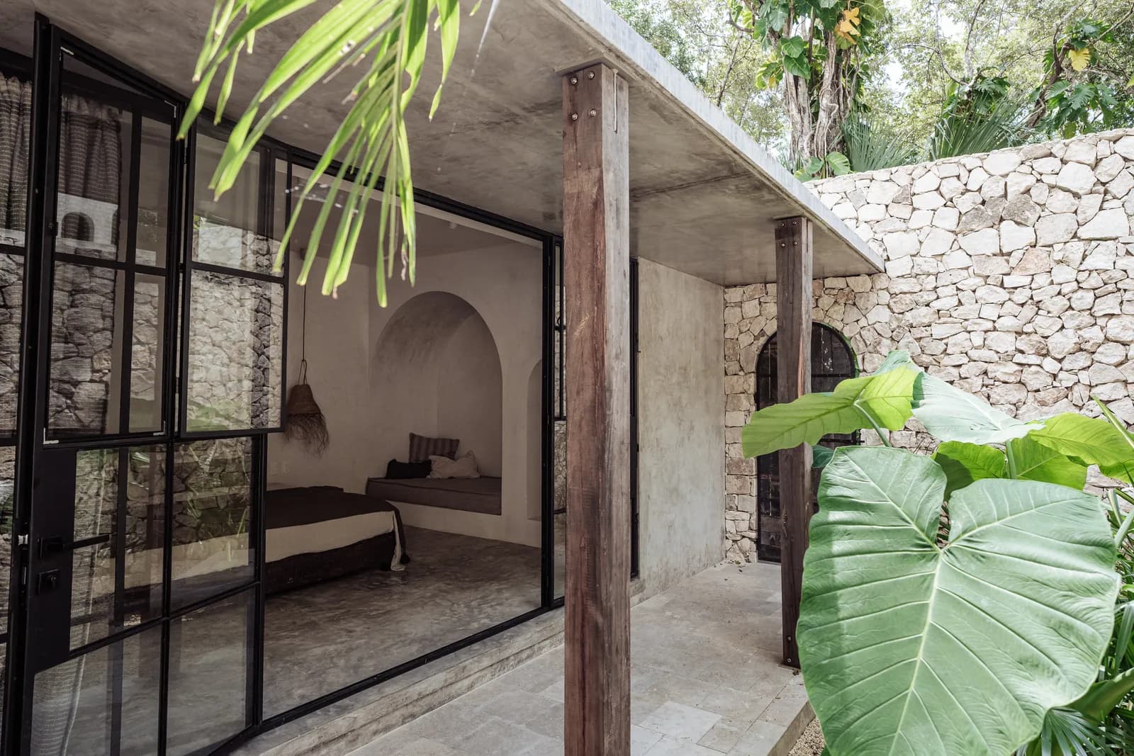 Villa 1 private entrance with stone wall and jungle planting