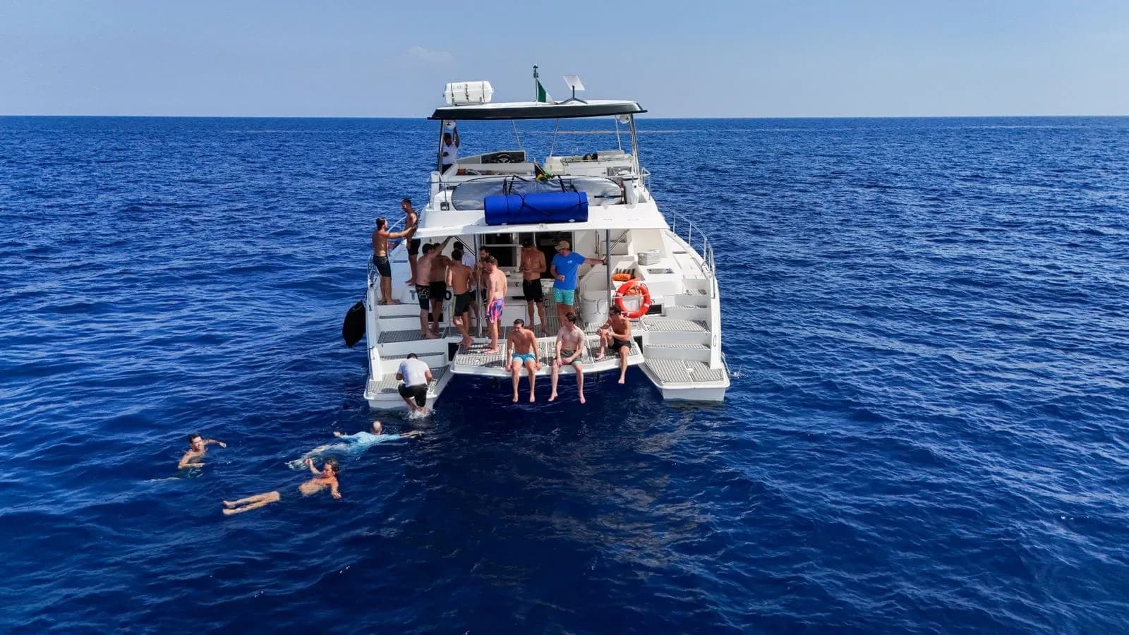 Guests swimming from a catamaran on a Riviera Maya boat excursion
